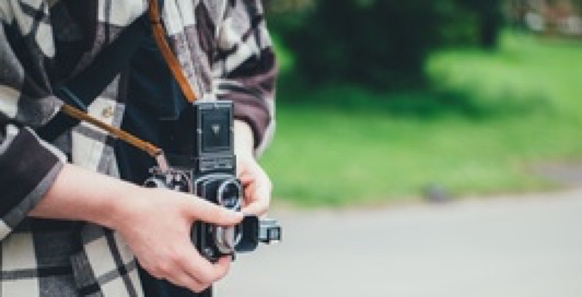 person holding a vintage photographer's camera