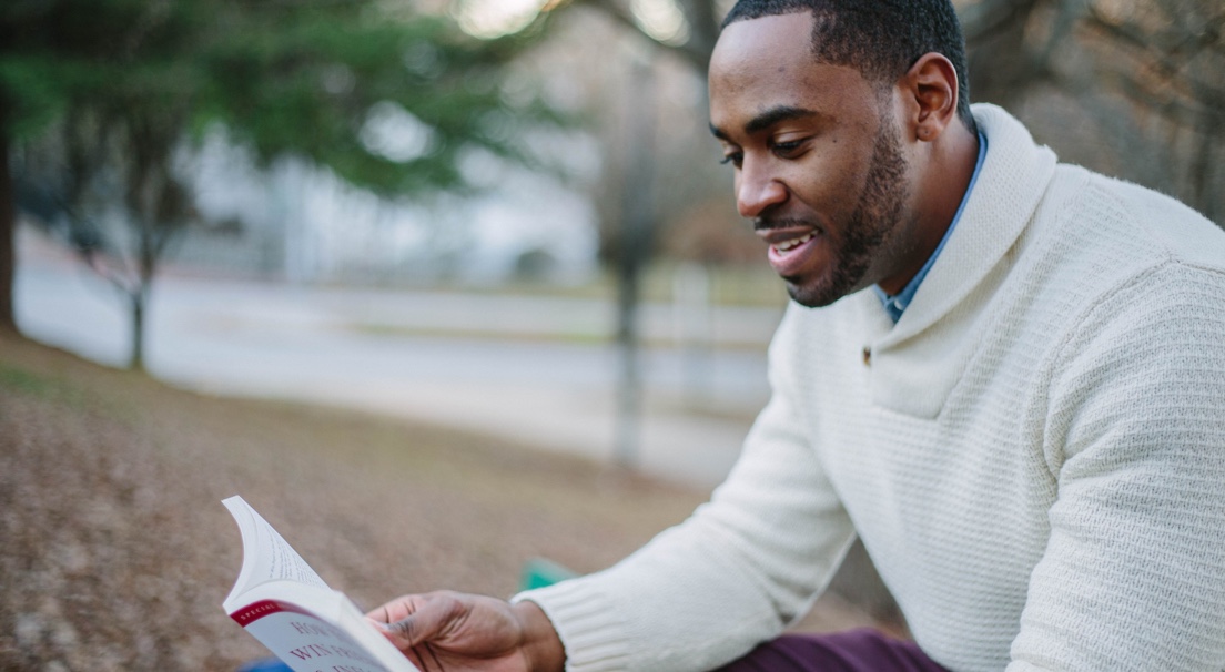 Gentleman reading a book outside