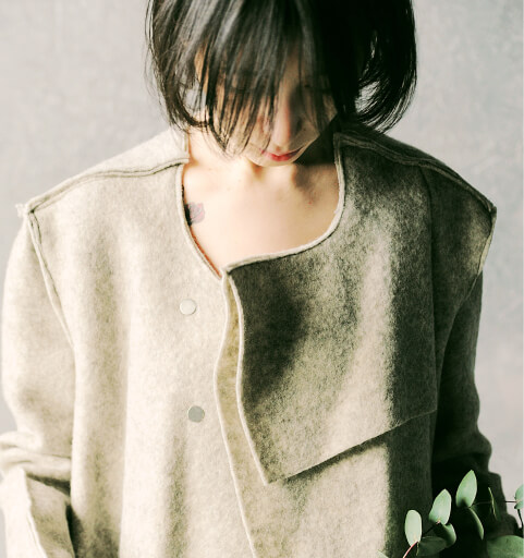 high-fashion female model in distressed grey woolen coat